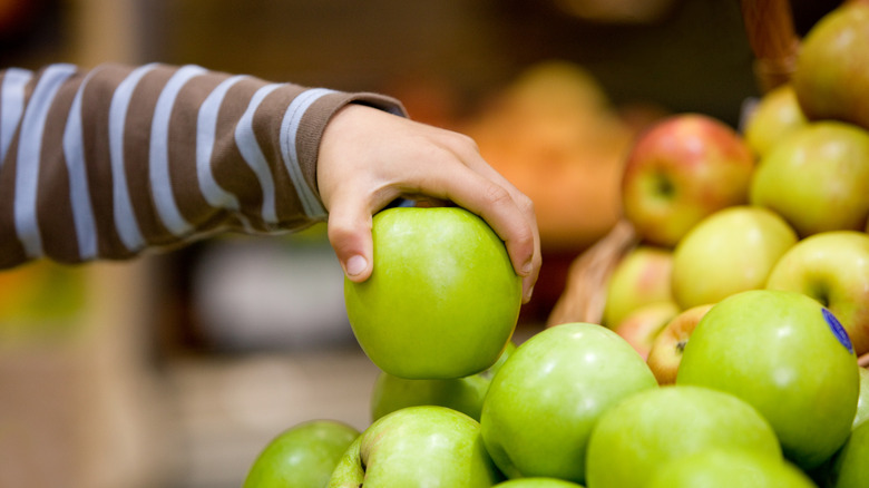 Hand grabbing an apple