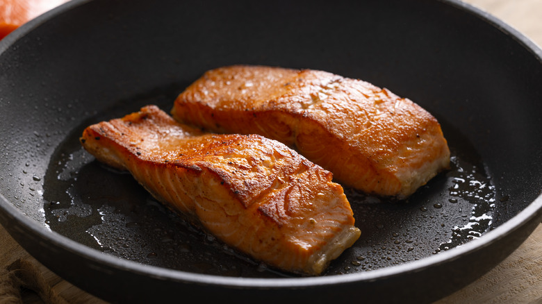 Salmon filets cooking in a pan