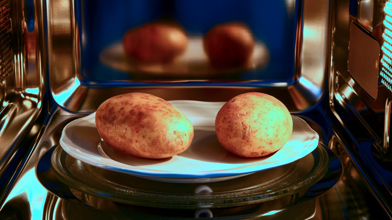 Two potatoes on a plate in the microwave