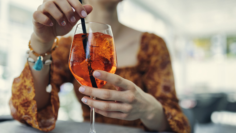 Person with an Aperol Spritz.