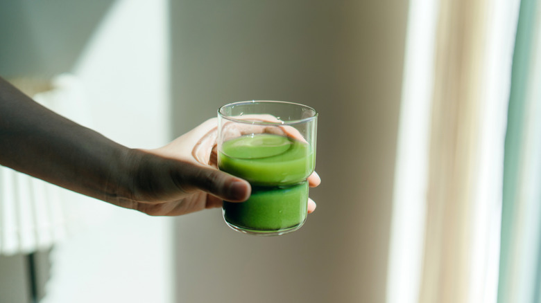 Person holding a glass of prepared matcha