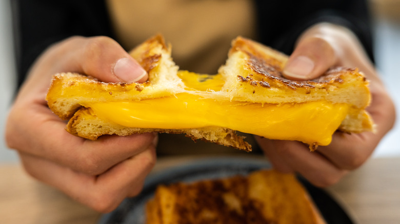 Person pulling apart a grilled cheese sandwich