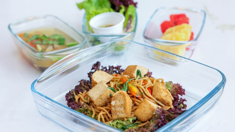 stir-fried tofu and noodles with dishes in background