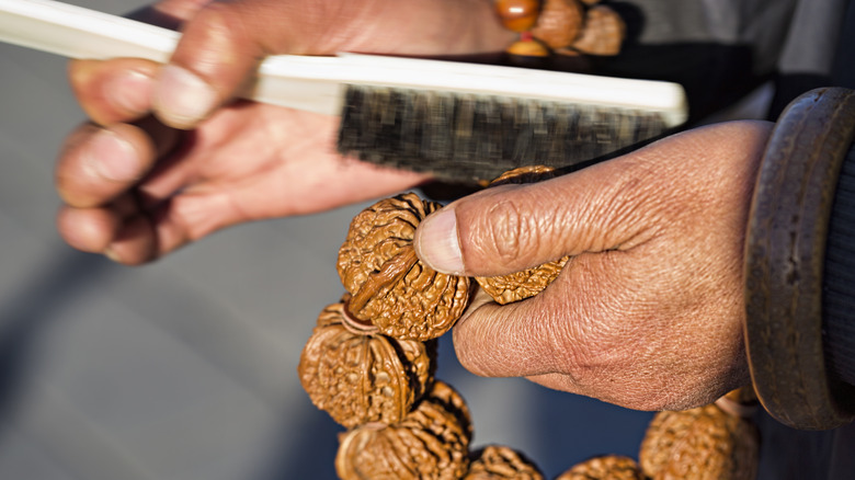 hands polishing nutmeg jewelry