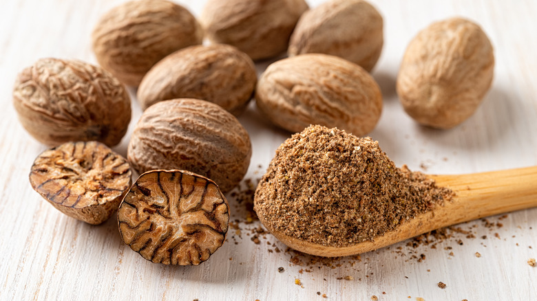 grated nutmeg in wooden spoon