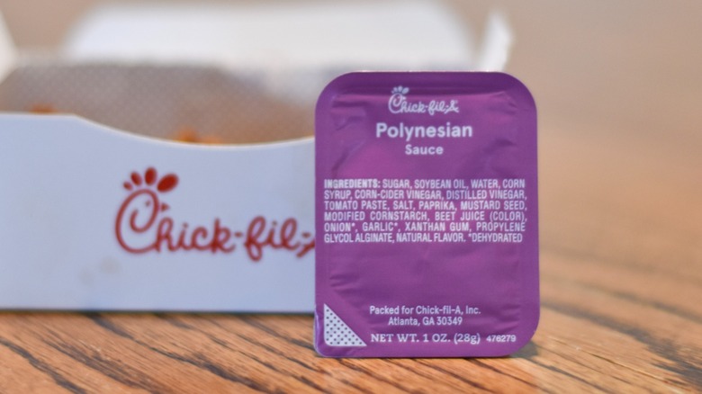 Chick-fil-A Polynesian sauce in front of a box of nuggets on a wooden table