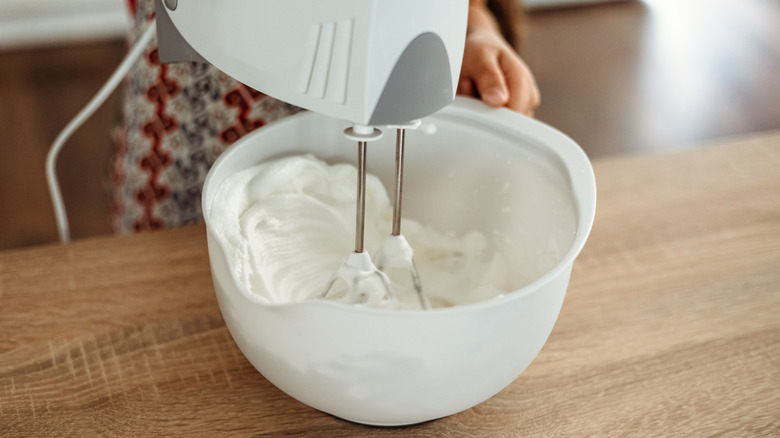 Hand mixing yogurt pudding in a large bowl