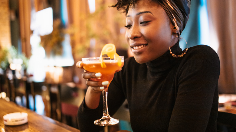 Woman enjoying brandy cocktail at a bar