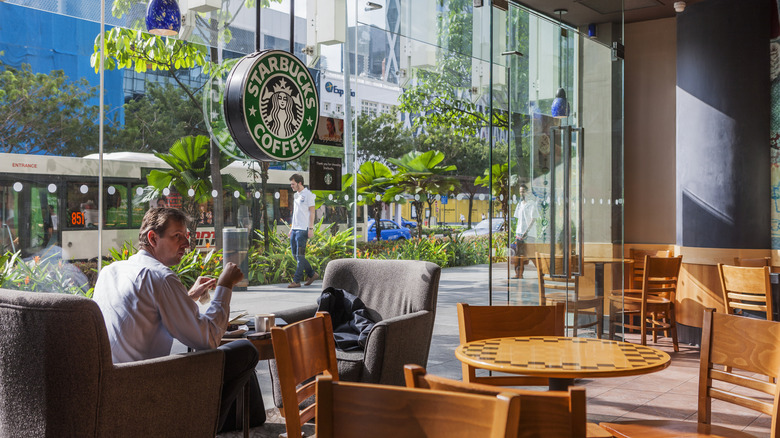 a man sits at a table inside a Starbucks