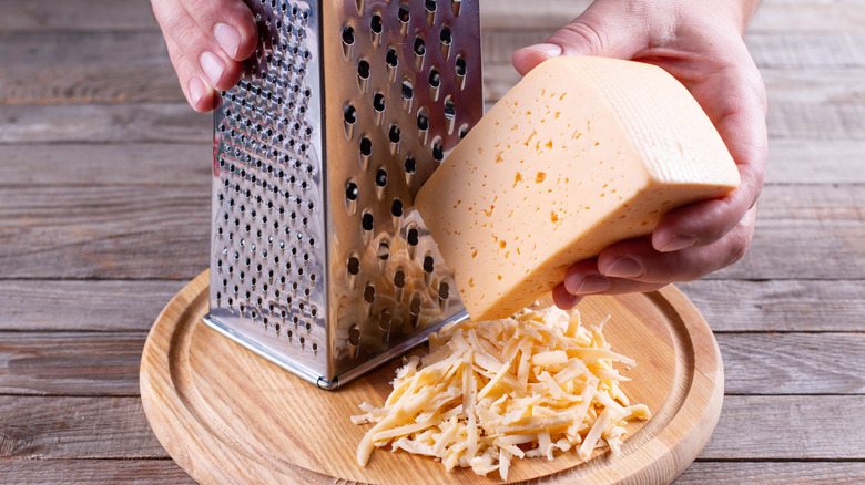 Pair of hands grating cheese