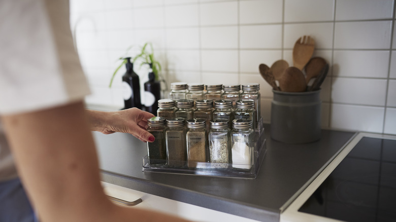 Person choosing spices from a rack