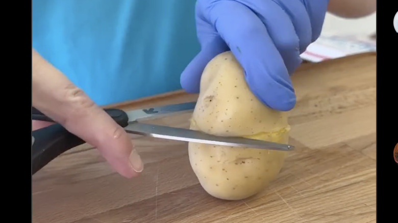 Scoring a potato using kitchen scissors