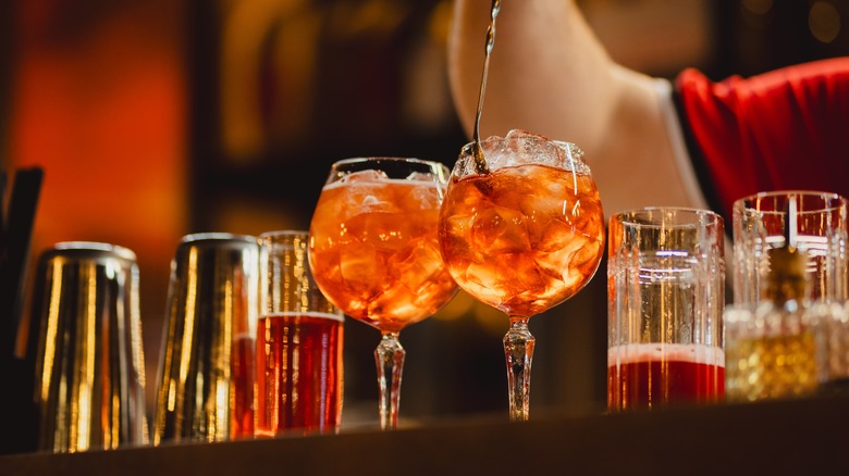 two orange cocktails on bar