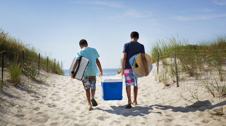 walking with cooler on beach