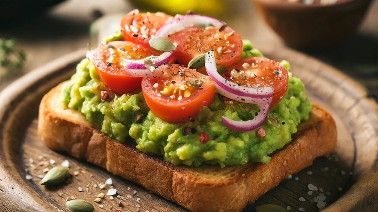 Sliced tomatoes on avocado toast