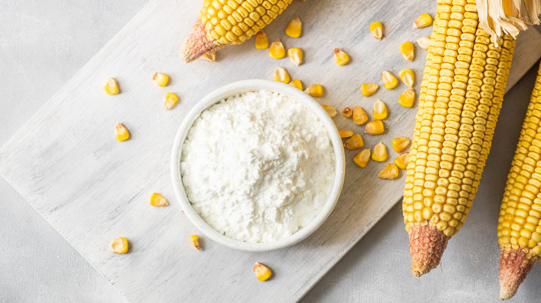 Bowl of cornstarch with ears of corn by it