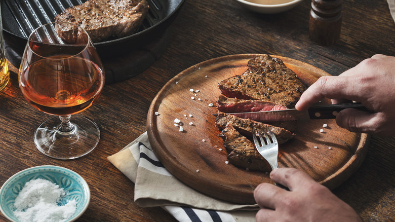 Cognac snifter next to person eating steak