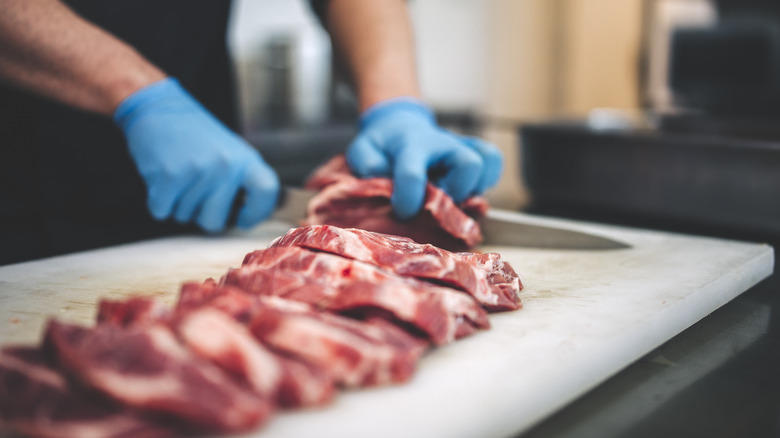 chef cutting pork