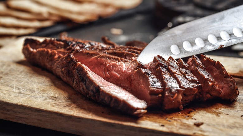 Sliced flank steak on board