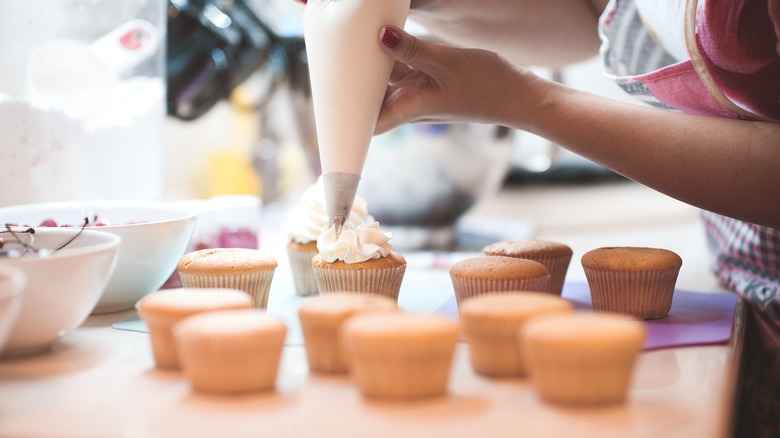 piping icing onto cupcake