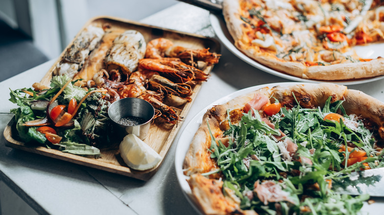 Fancy pizzas on plates with side dishes