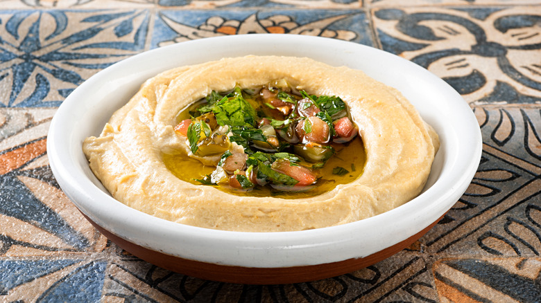 Hummus in a bowl on a tiled table