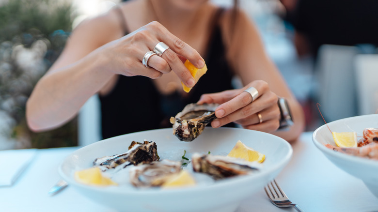 A woman eating oysters 