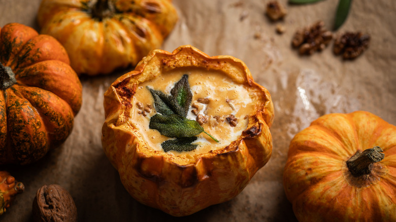 sage leaves garnishing squash soup in gourd shell