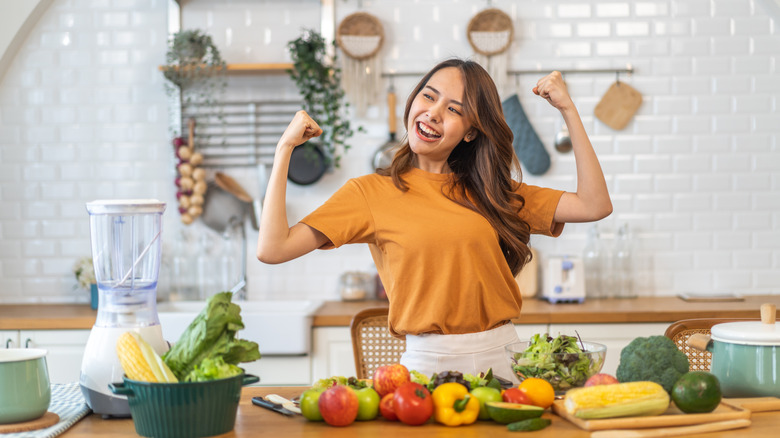 women flexing in front of pile of fresh produce