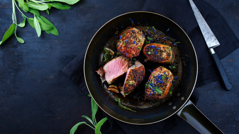 veal medallions in pan with sage leaves and sauce