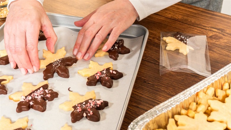 Hands preparing cookies and putting them on tray