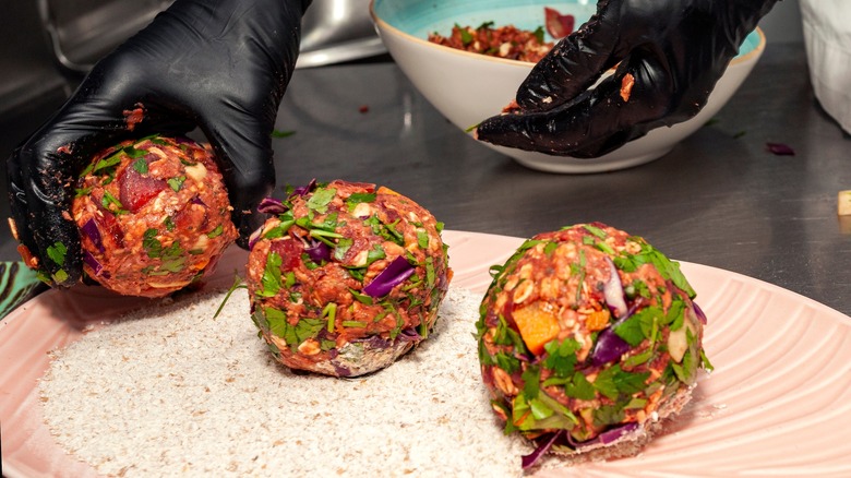 Gloved hands forming veggie burger patties