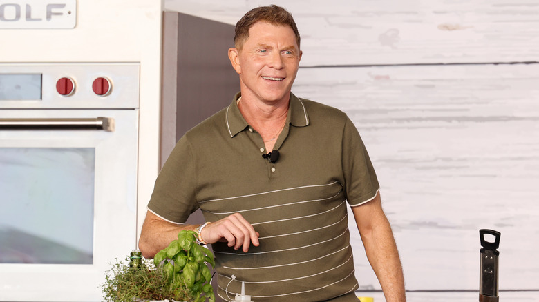 Bobby Flay smiles during a cooking demo at an event