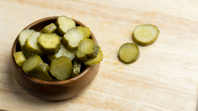 Wooden bowl of dill pickle slices