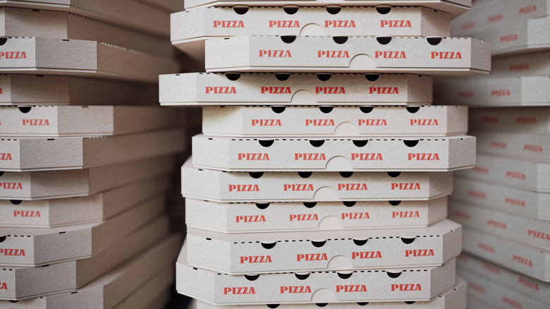 A stack of white pizza boxes