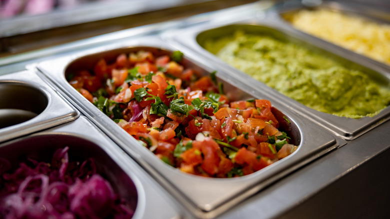 Pico de gallo and guacamole in catering bins on buffet