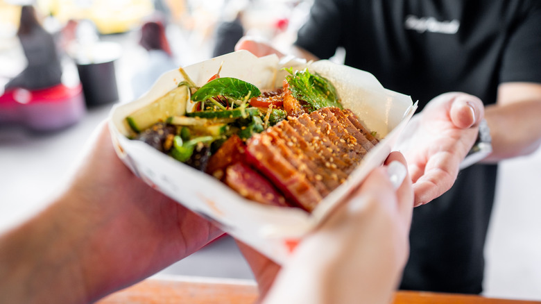 Plate of vegetables and grilled protein at outdoor restaurant