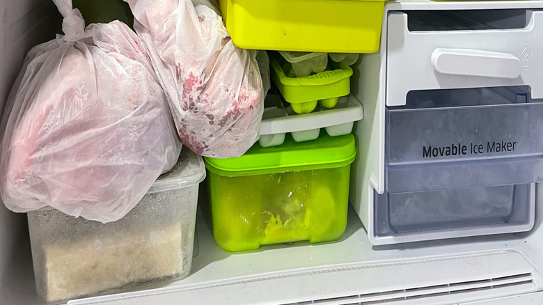 Woman storing food container in freezer