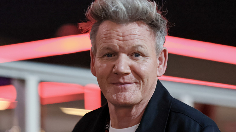 Chef Gordon Ramsay at an event in front of neon lights