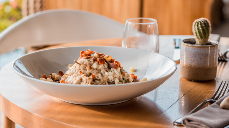 Tuna salad topped with bacon in a white bowl