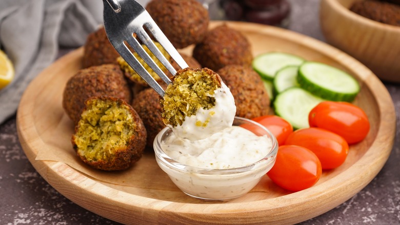 Falafel ball dipped into yogurt sauce