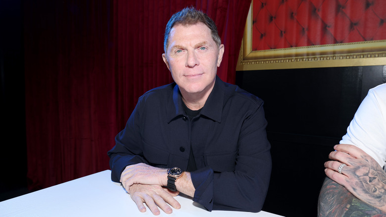 Bobby Flay sitting down and looking into camera