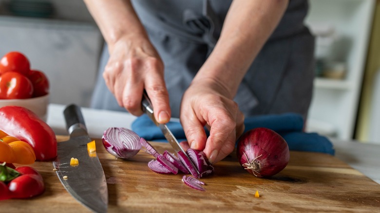 Hands chopping red onions