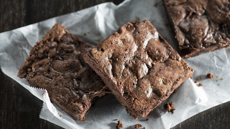 Three brownie squares on wax paper