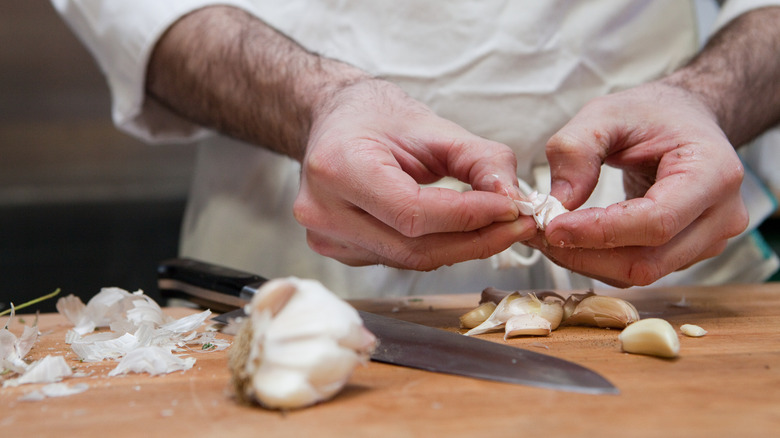 Chef peeling garlic cloves by hand