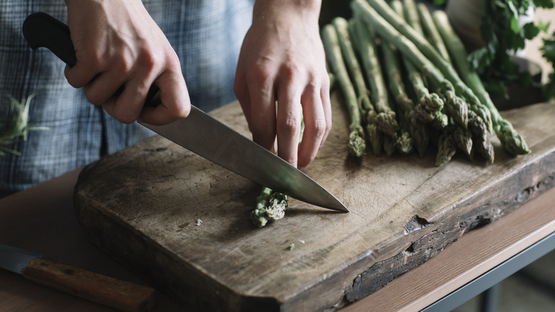 A person chopping asparagus