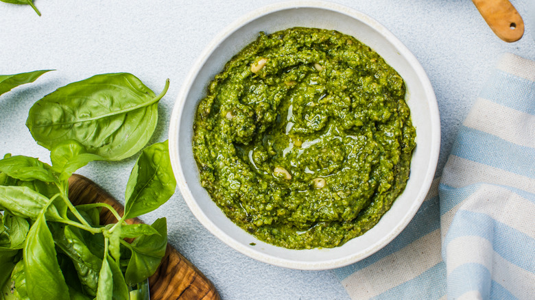 A bowl of cream pesto garnished with pine nuts