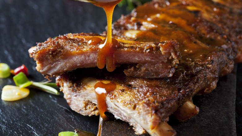 BBQ sauce drizzles onto ribs