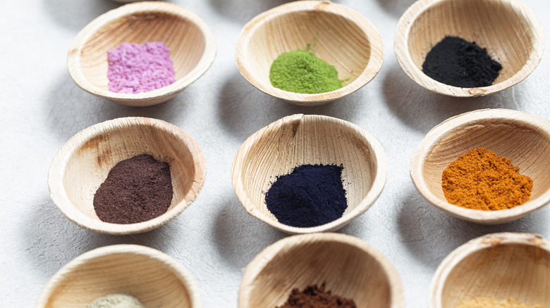 Various natural color dyes in small wooden bowls