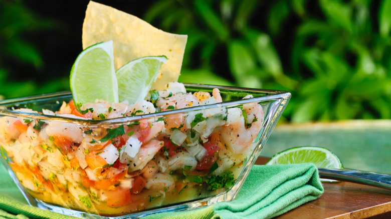 A bowl of Mexican ceviche with two limes